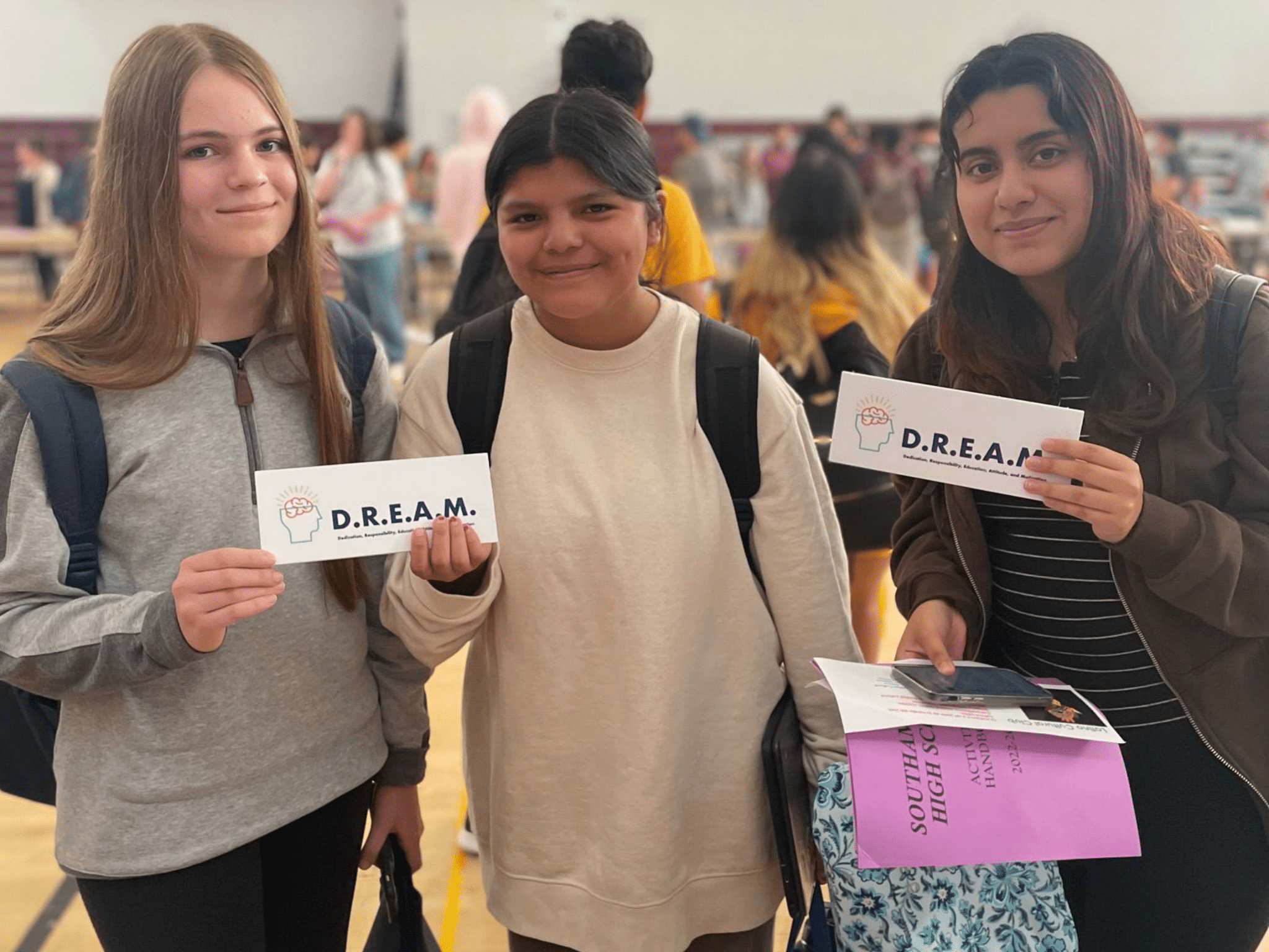 3 girls hold a sign