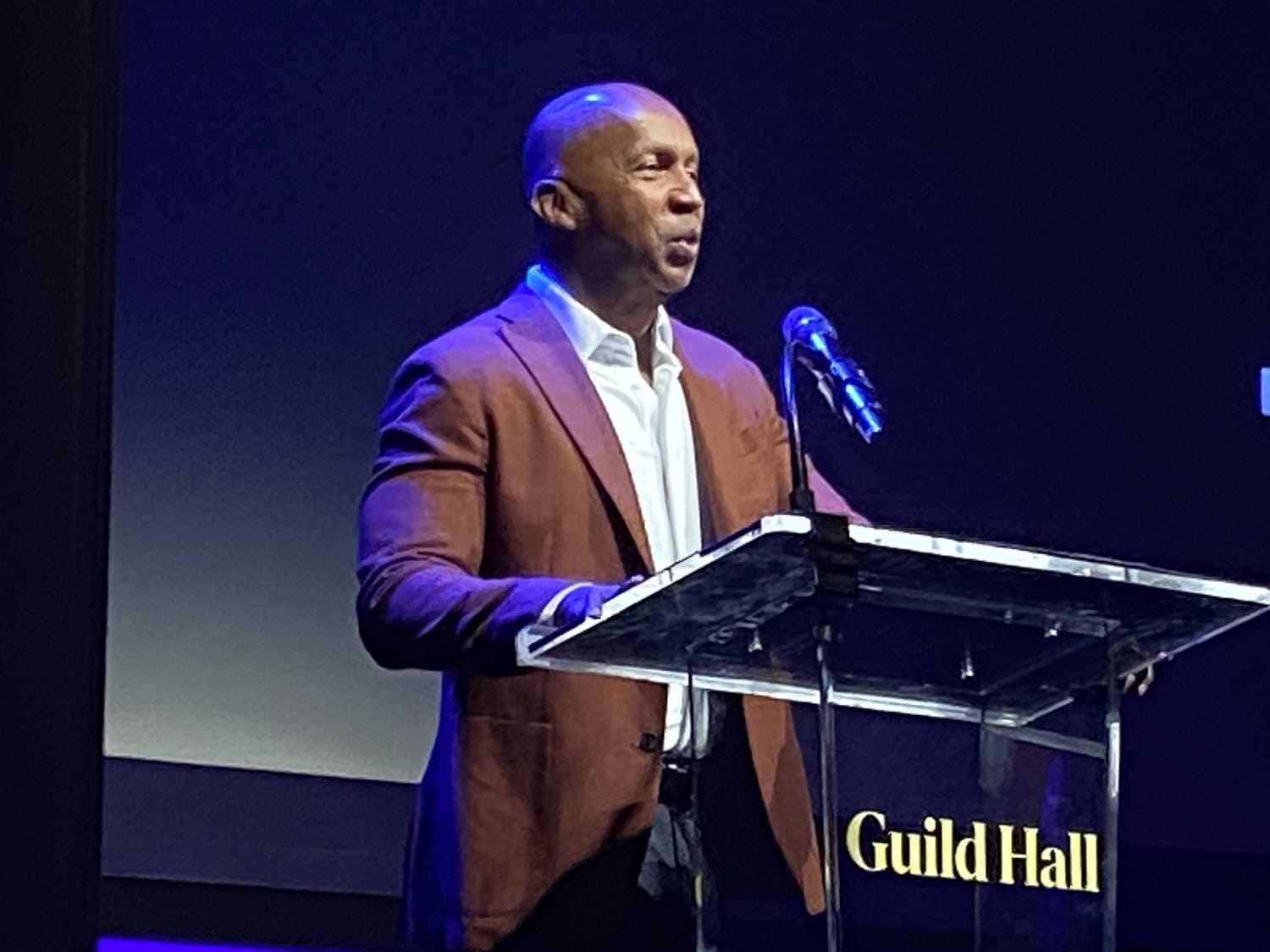 A black man speaking at a podium