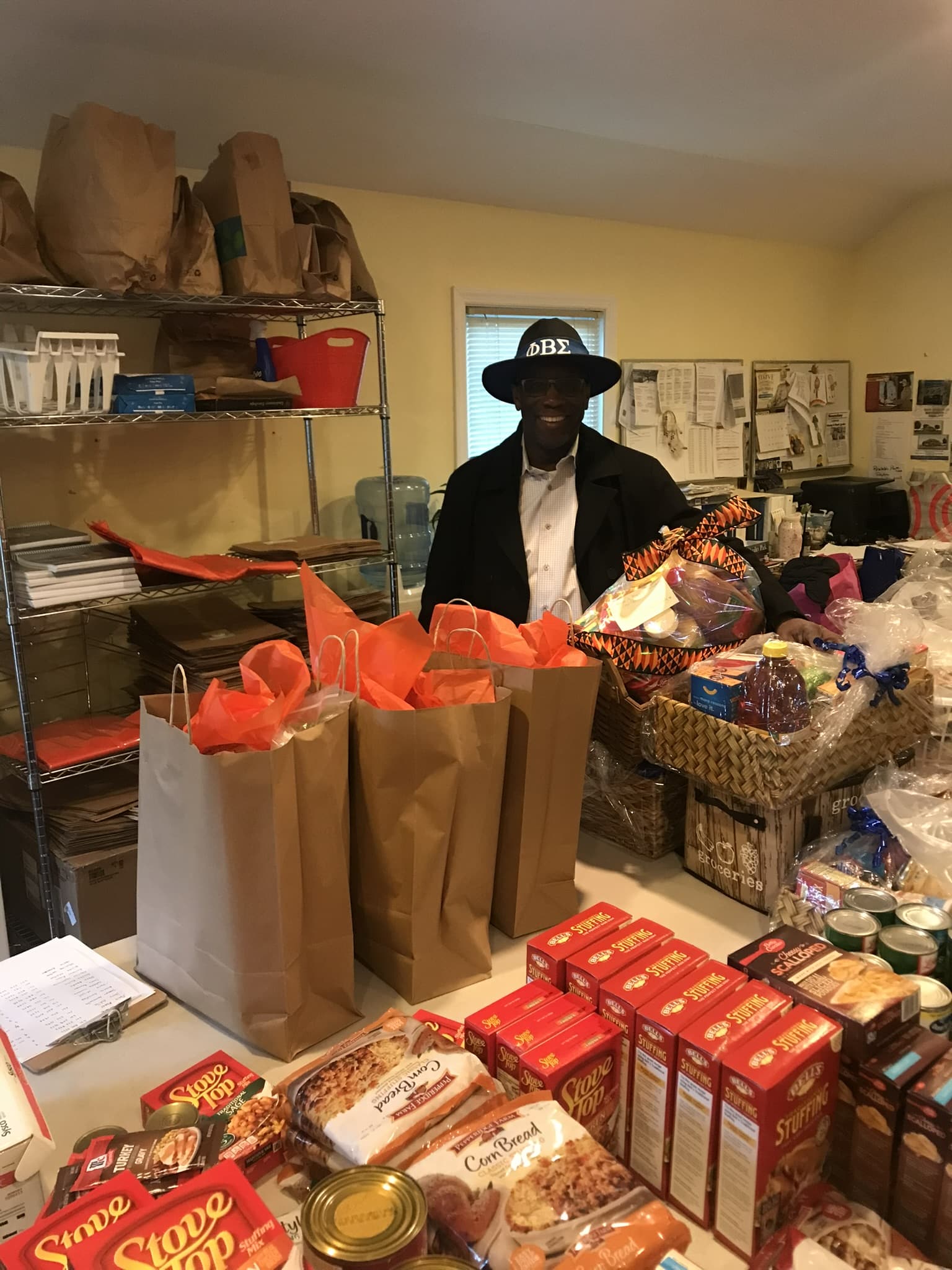 A person standing behind grocery bags and food at the pantry